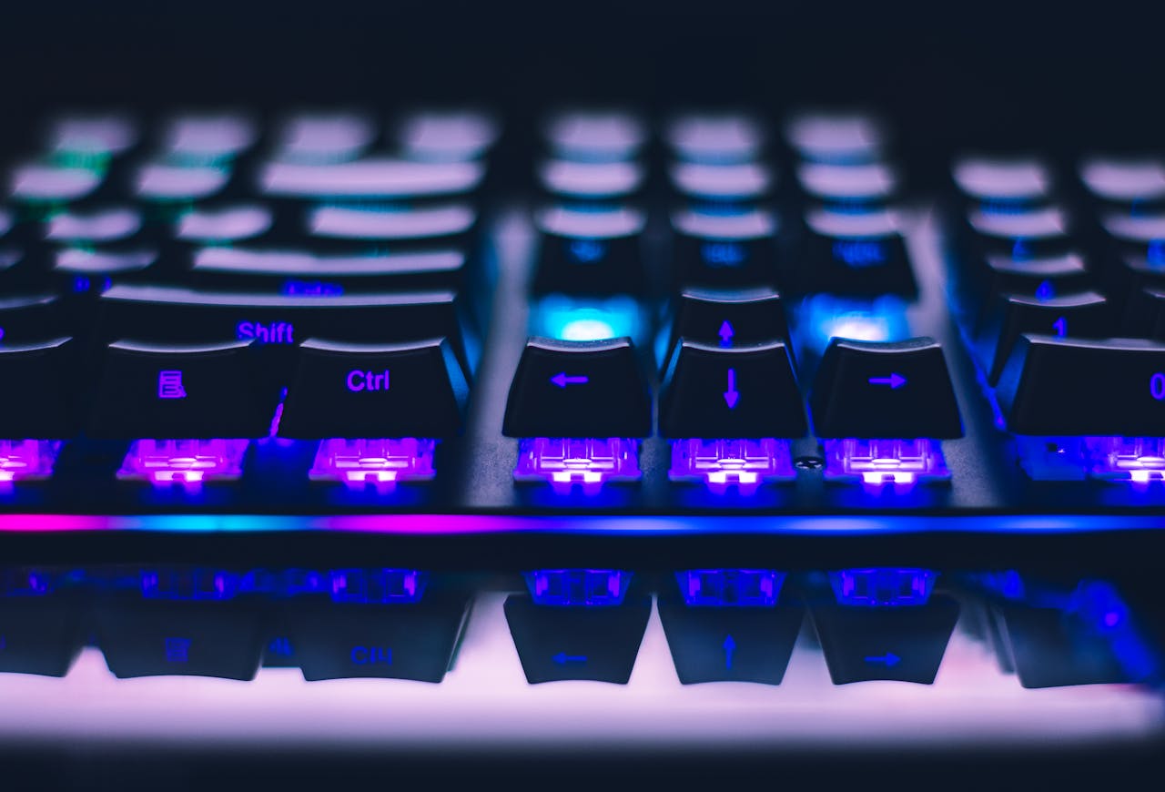 gallery-03 A detailed close-up of illuminated mechanical keyboard keys with focus on blue and purple lights.